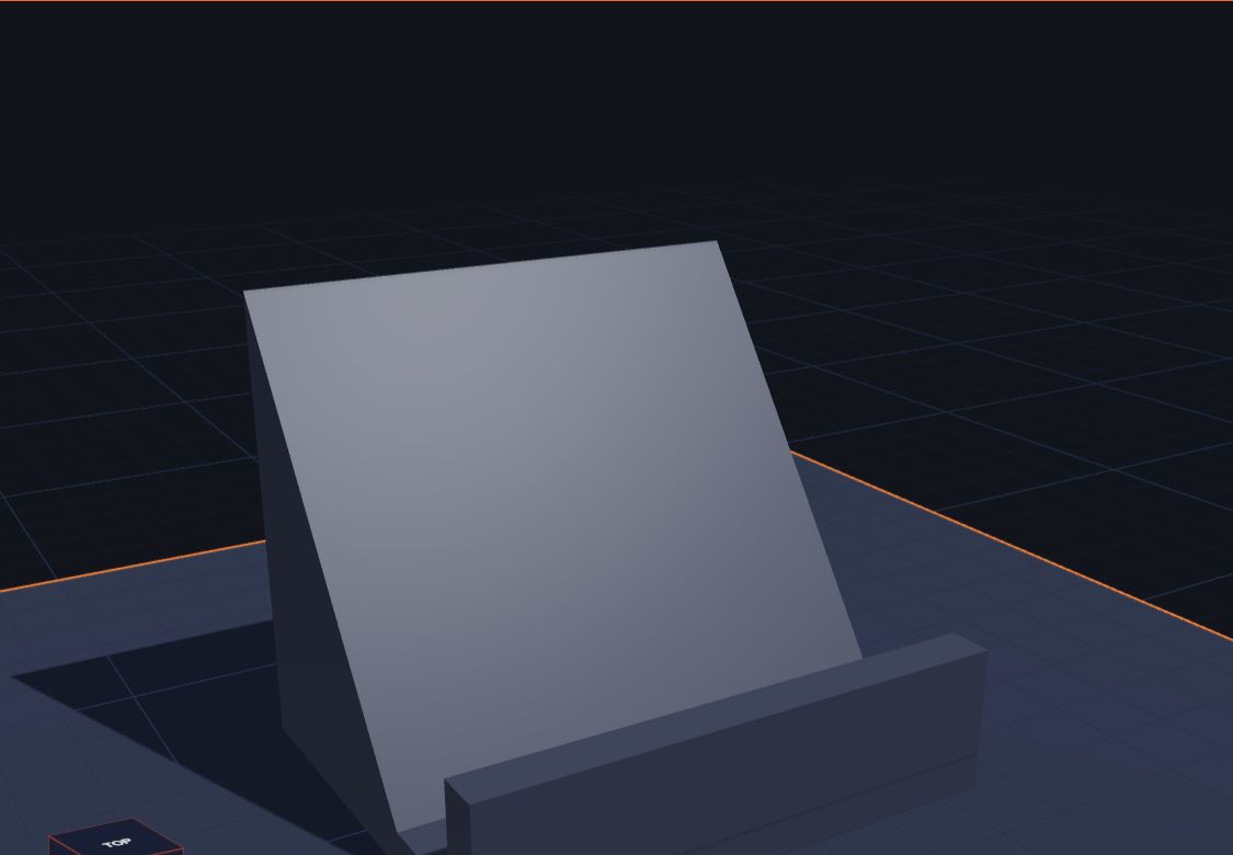 A grey phone stand: a flat base, a tall ramp at the back and a small lip at the front